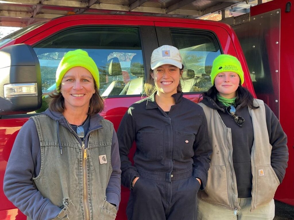 Laura Mele, Vanessa Igoe, and Rachel Lawlor standing in front of a truck.